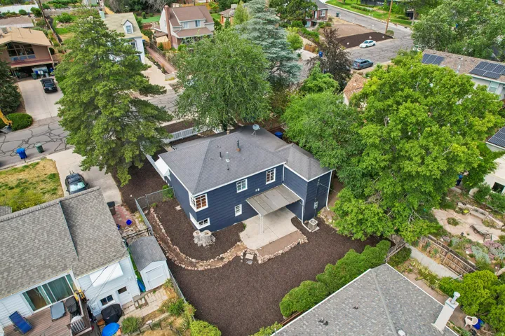 Dark-sided residence with white trim and a dark shingled roof