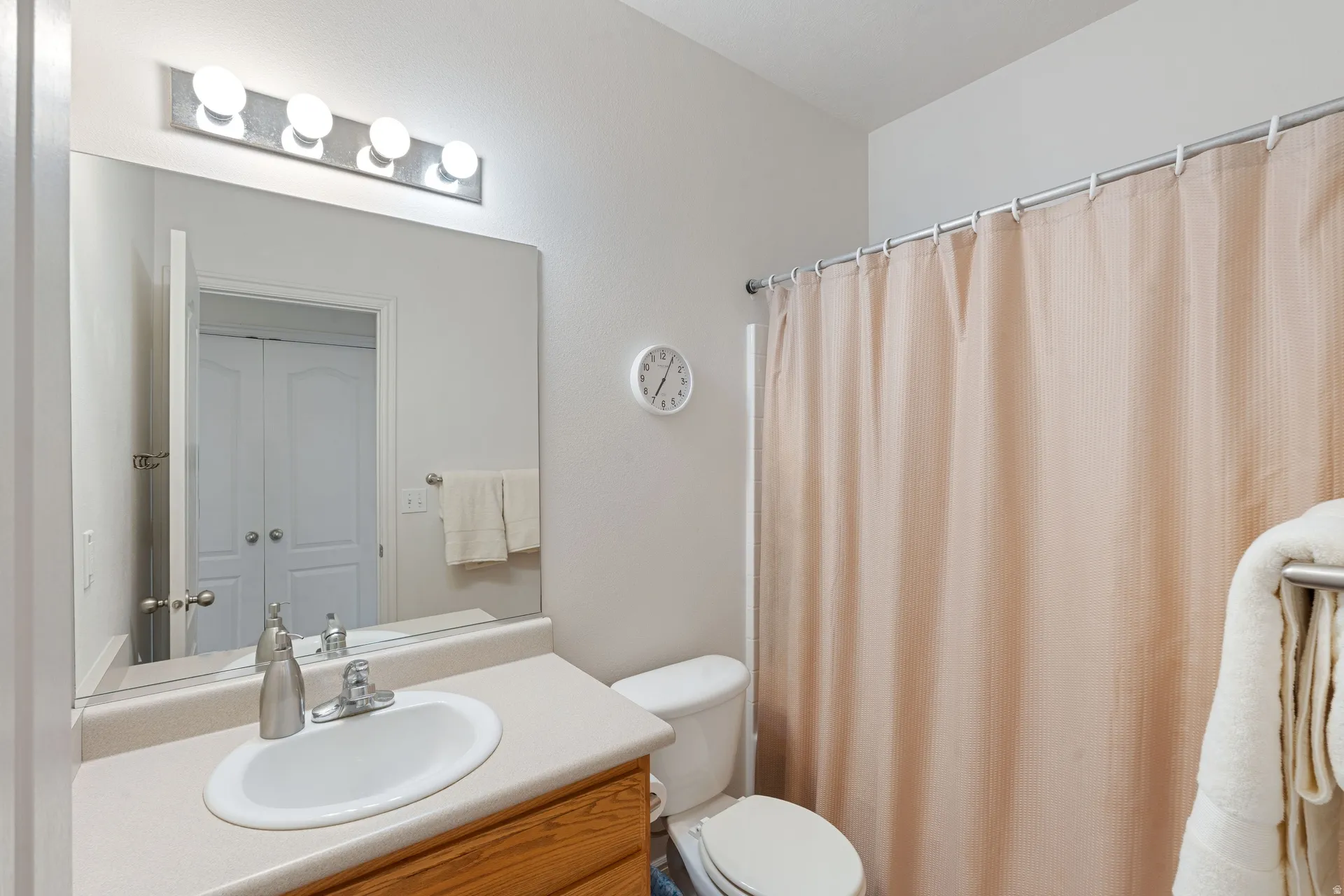 Bathroom featuring a vanity with a laminate countertop, an oval sink, and a chrome faucet