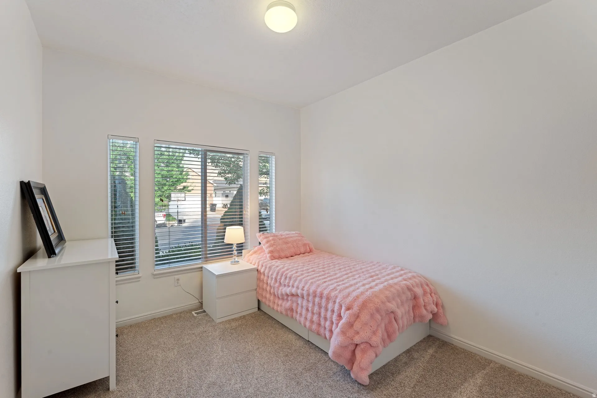 Room featuring broadloom carpet, white walls, and a vaulted ceiling