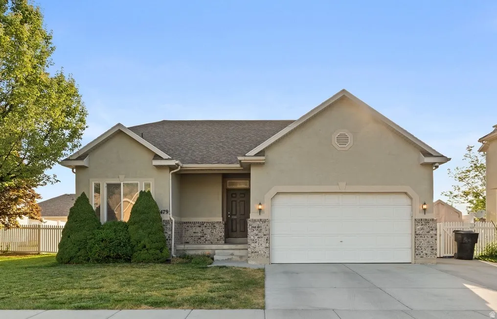 Stucco exterior featuring a prominent two-car garage with overhead door