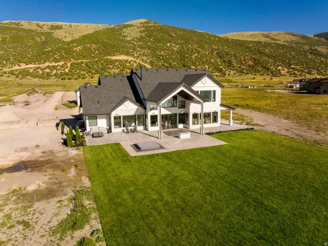 Modern farmhouse architecture featuring white vertical siding, black-framed windows, and a dark shingle roof