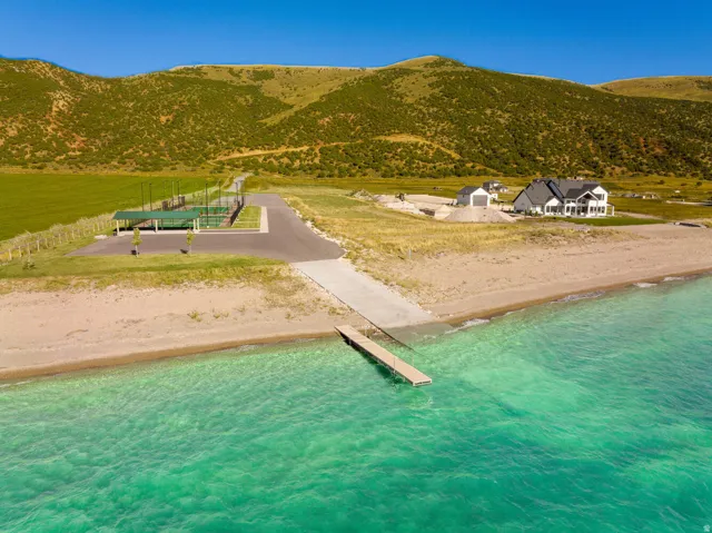 Expansive beachfront property featuring a private dock, boat ramp, and sandy shoreline