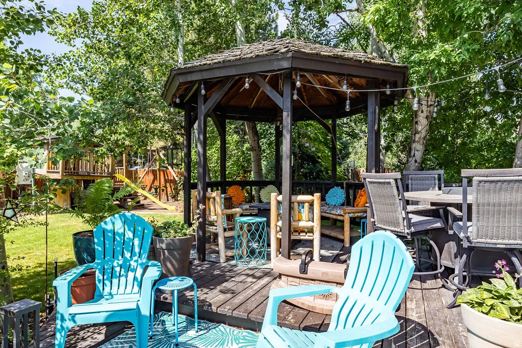 Expansive wood deck with a built-in gazebo featuring a shingled roof