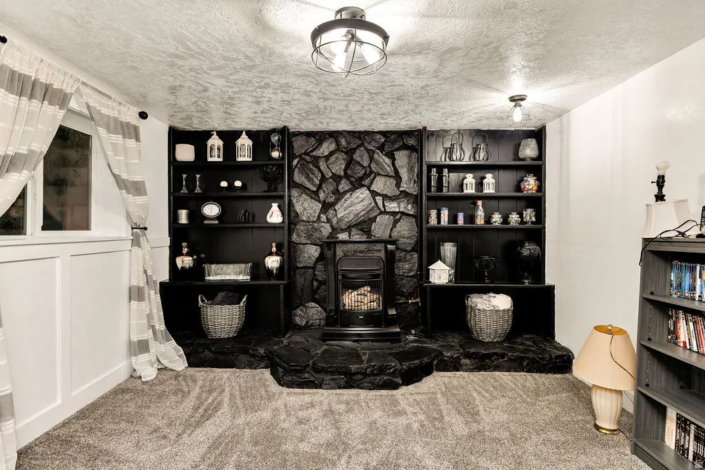 Stone-clad fireplace with a built-in hearth, flanked by symmetrical built-in shelving units