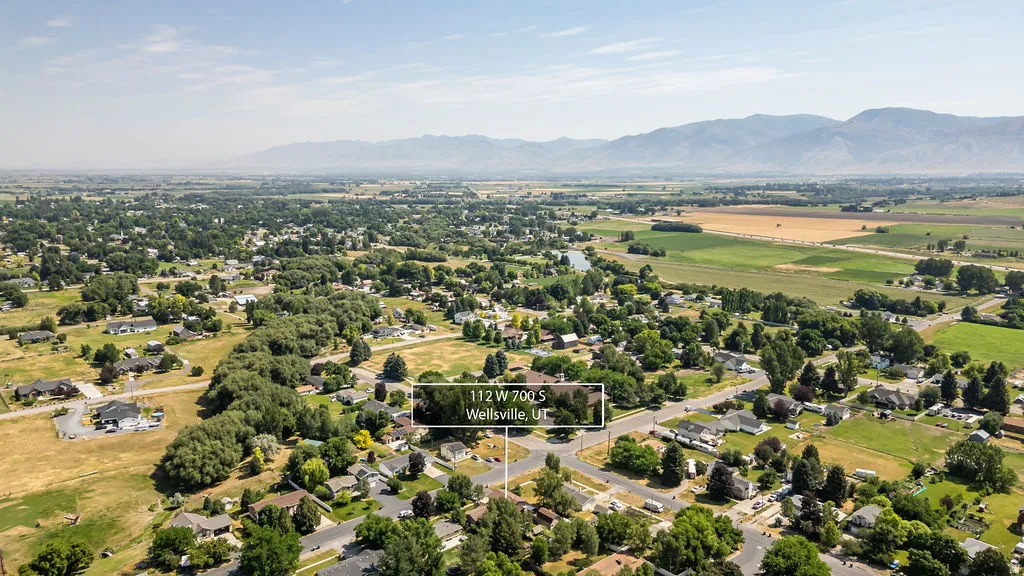 Aerial perspective showcasing a residential area with established trees and surrounding agricultural lands