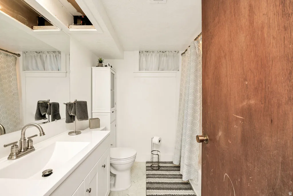 Bathroom featuring a white vanity with an integrated sink, brushed nickel faucet, and under-sink cabinetry