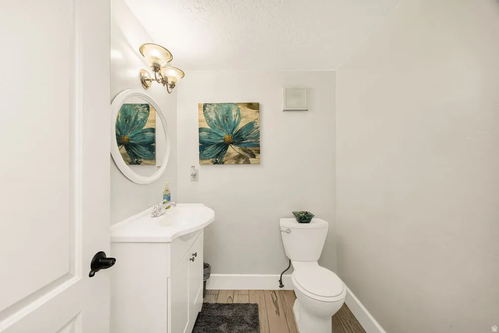 Bathroom featuring a white vanity with integrated sink, coordinating white oval mirror, and a three-light fixture