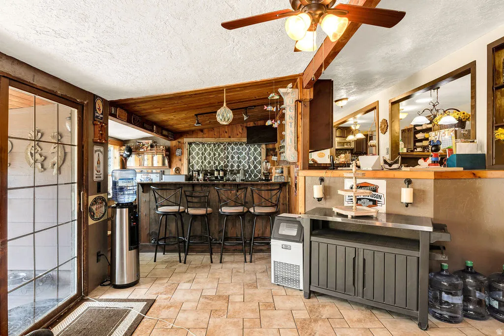 Tiled flooring throughout this space featuring wood-paneled walls and ceiling accents