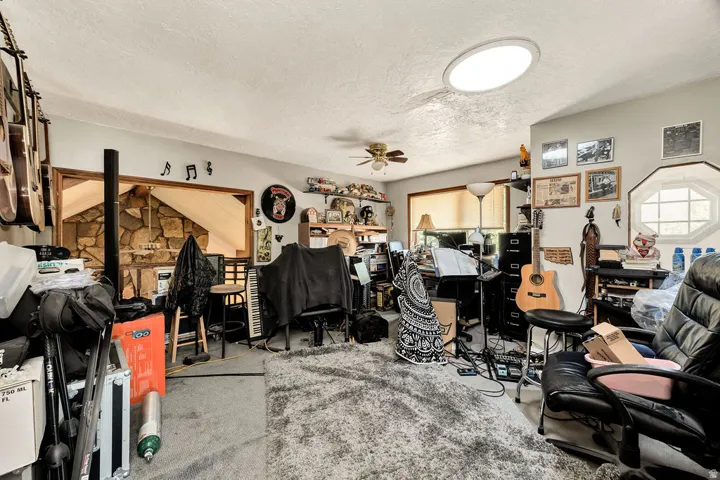 Carpeted room featuring a ceiling fan, recessed lighting, and a large window with blinds