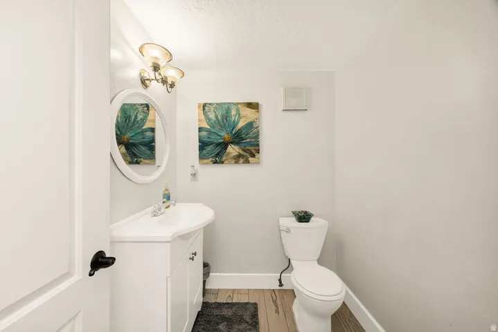 Bathroom featuring a white vanity with integrated sink, coordinating white oval mirror, and a three-light fixture