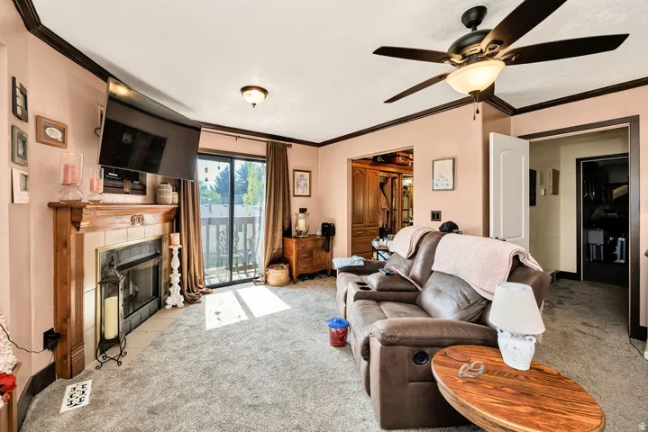 Living area with a fireplace, wood mantle, and tile surround