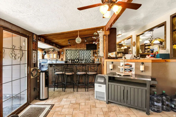 Tiled flooring throughout this space featuring wood-paneled walls and ceiling accents