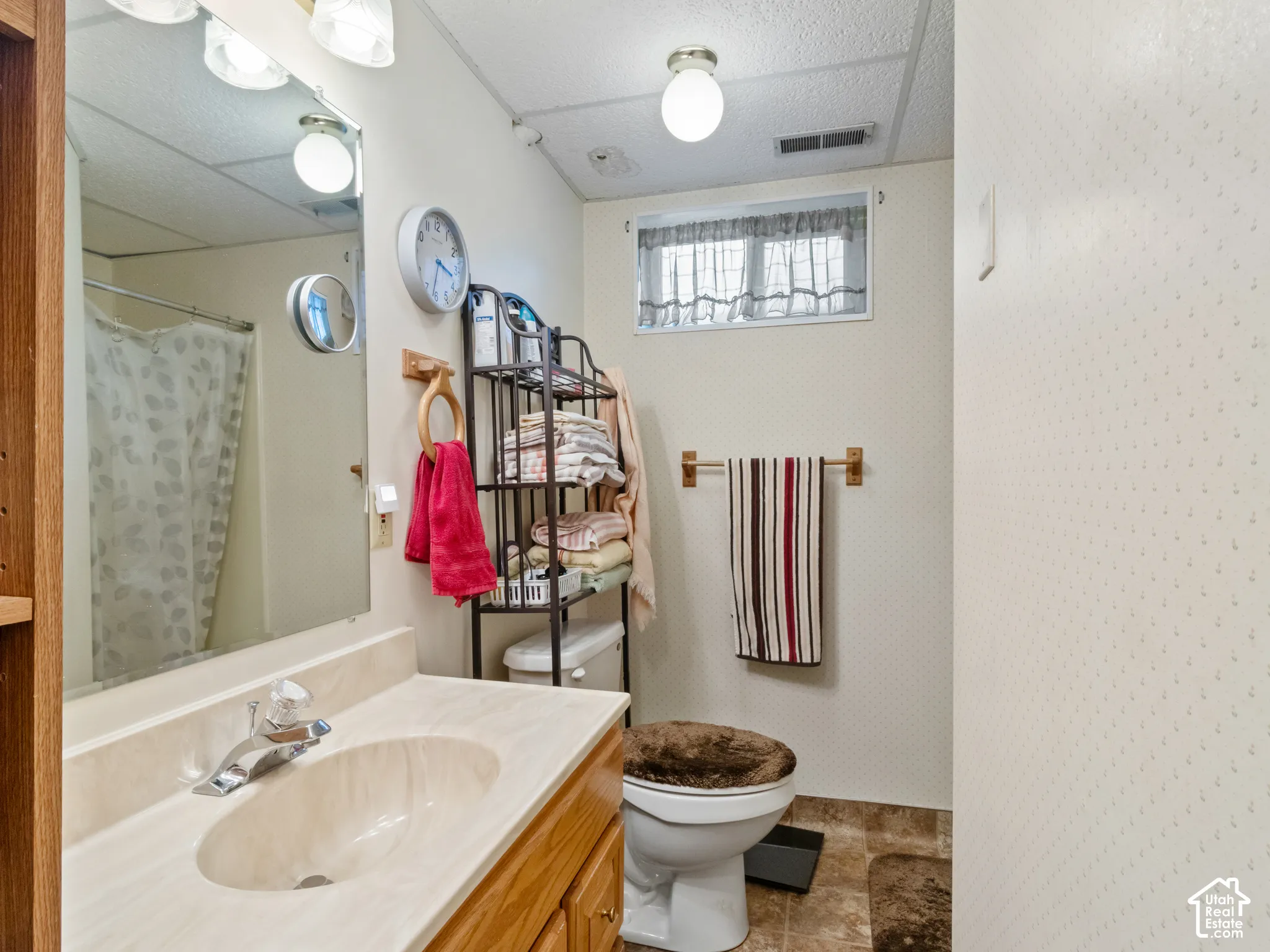 Bathroom featuring a wood-finish vanity with an integrated sink and chrome faucet
