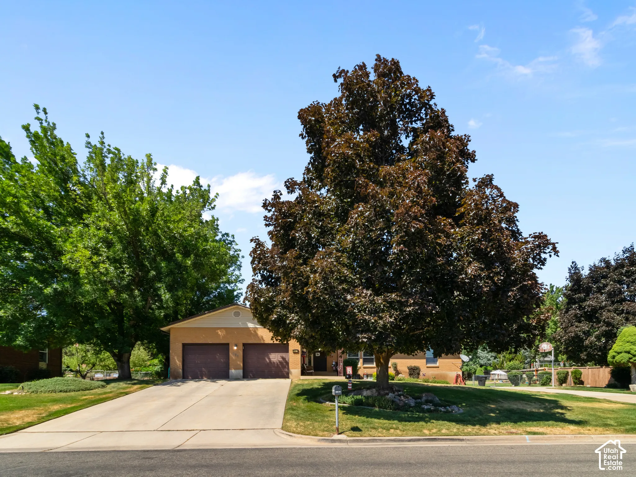 Single-story residence featuring a two-car garage with dark wood-finish doors