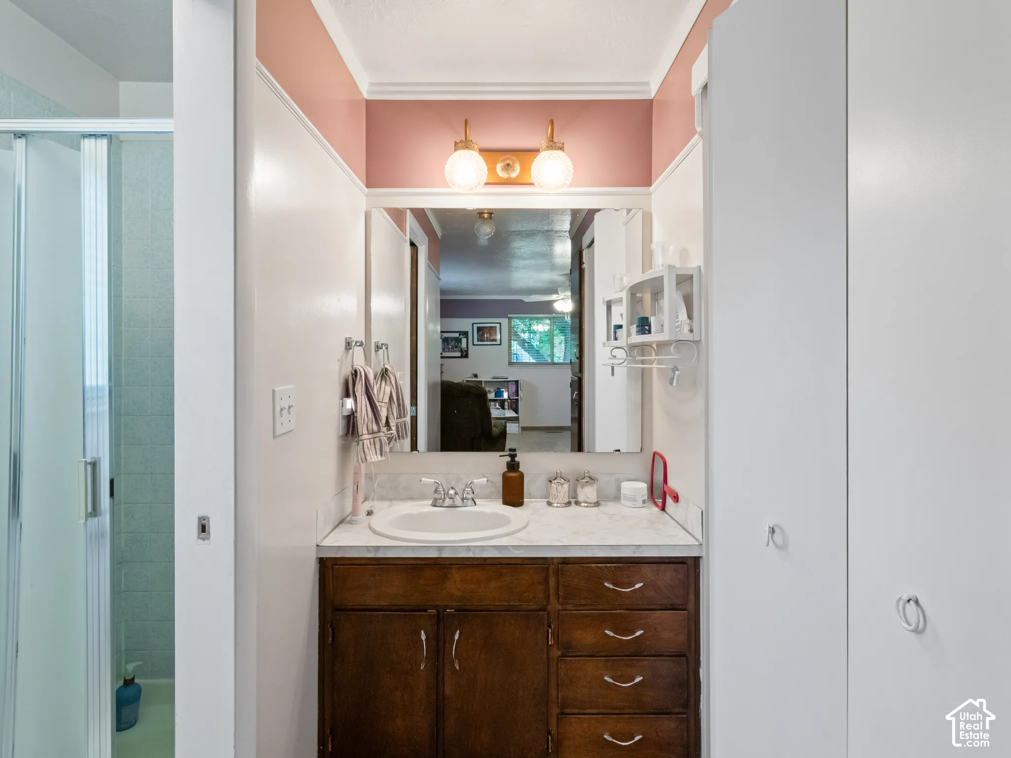 Vanity area featuring a single basin sink with chrome fixtures and a stone-finish countertop