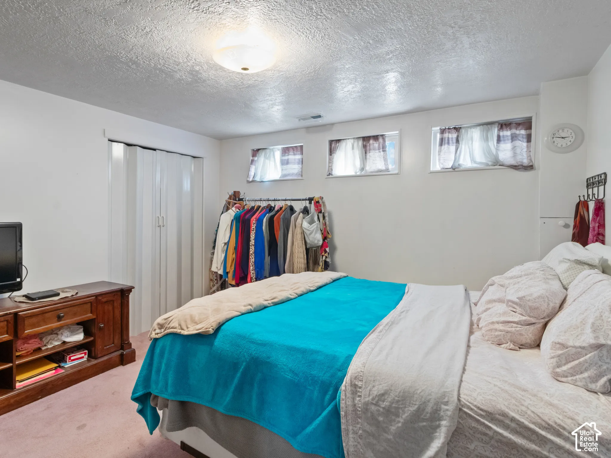 Bedroom featuring two small windows, a flush-mount ceiling light, and wall-to-wall carpeting