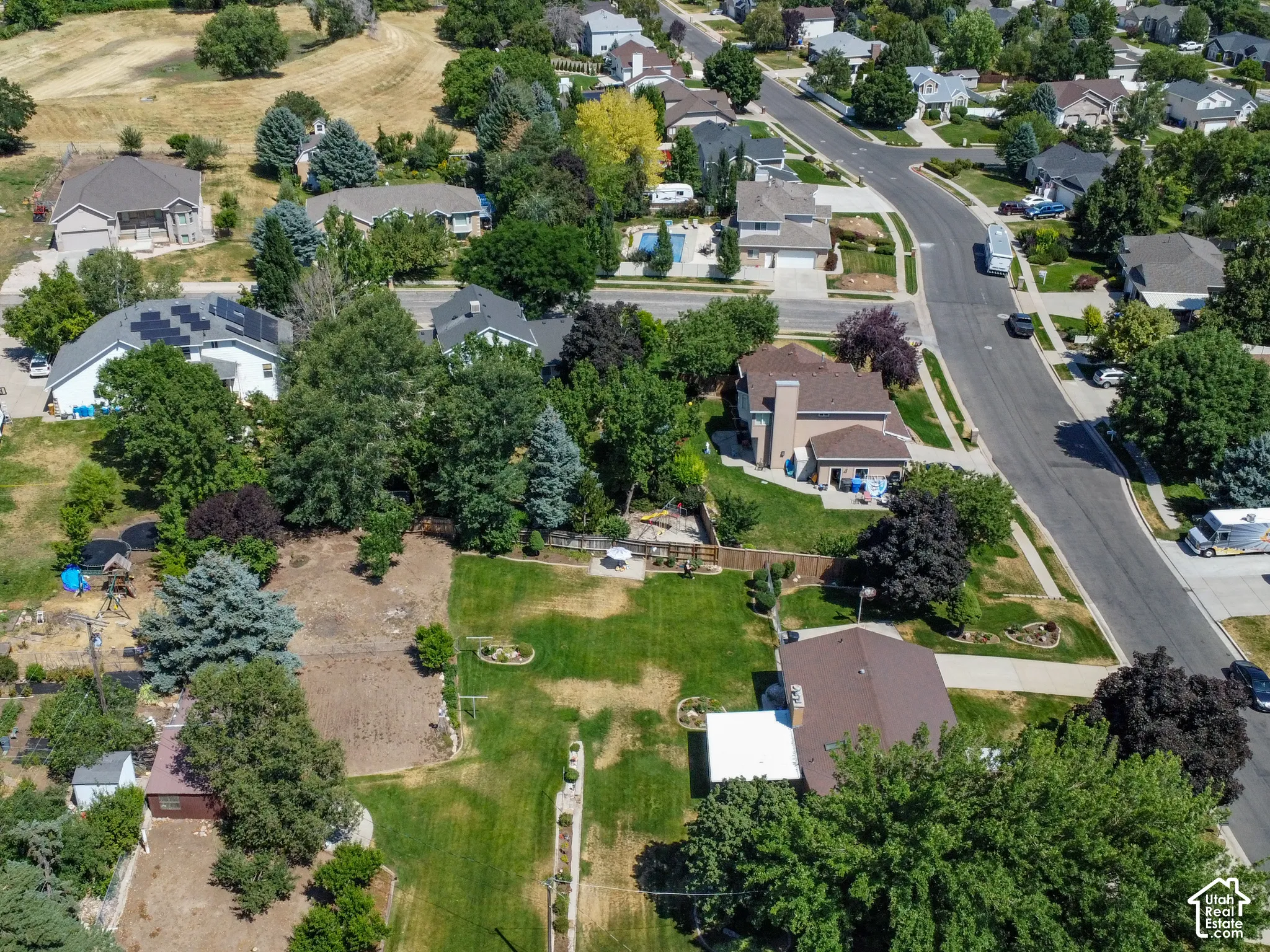 Expansive property featuring a large undeveloped lot, mature trees, and existing landscaping