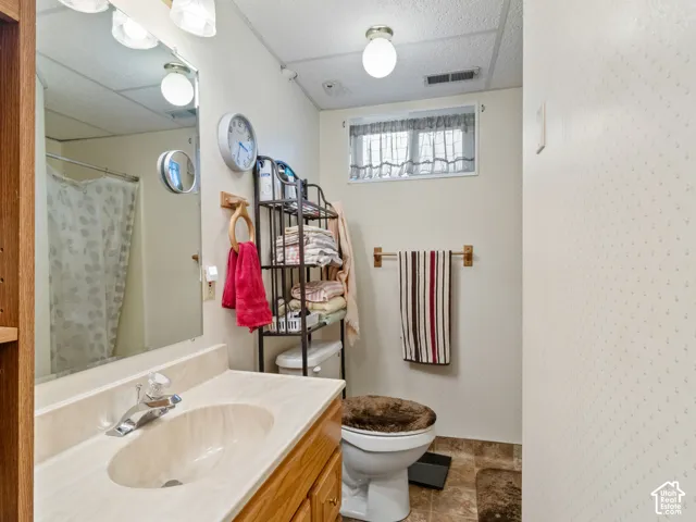 Bathroom featuring a wood-finish vanity with an integrated sink and chrome faucet