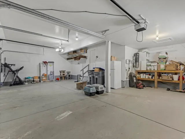 Spacious garage featuring a light gray concrete floor and white painted walls