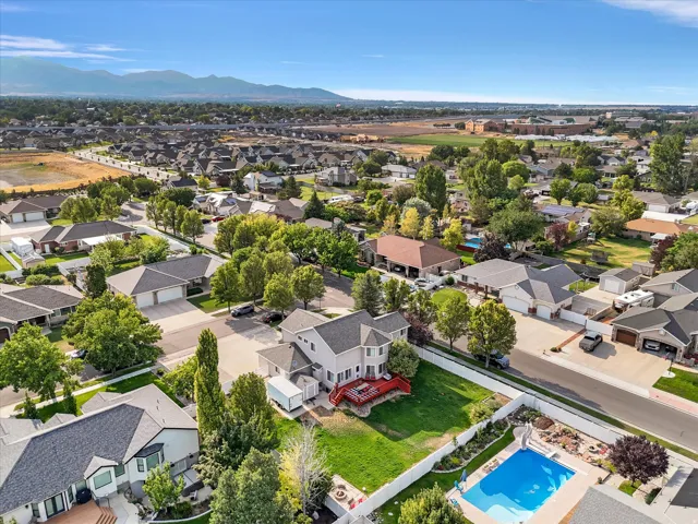 Two-story residence featuring a red deck, an expansive green lawn, and a private pool with a slide