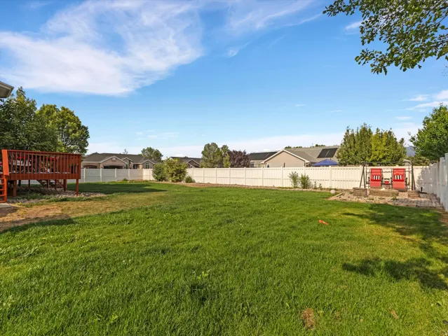 Expansive green lawn with a white privacy fence