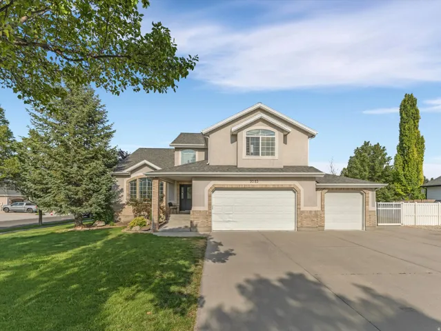 Two-story stucco and stone residence with a three-car garage
