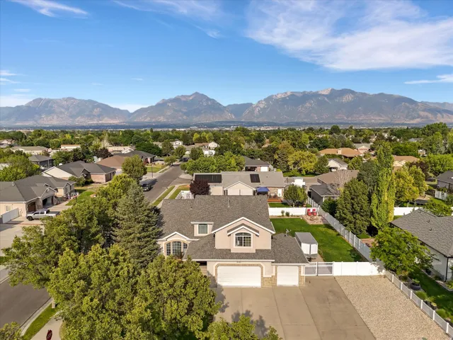 Spacious property featuring a two-story residence with a three-car garage, expansive driveway, and a large fenced backyard