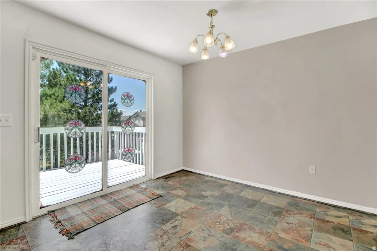 Interior space featuring multi-toned tile flooring, light neutral wall paint, and a multi-bulb ceiling fixture