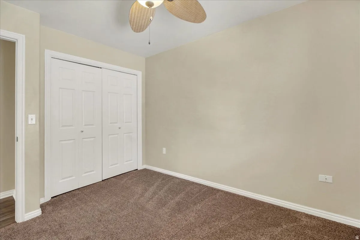 Room featuring neutral-toned walls, brown carpeting, and white baseboards