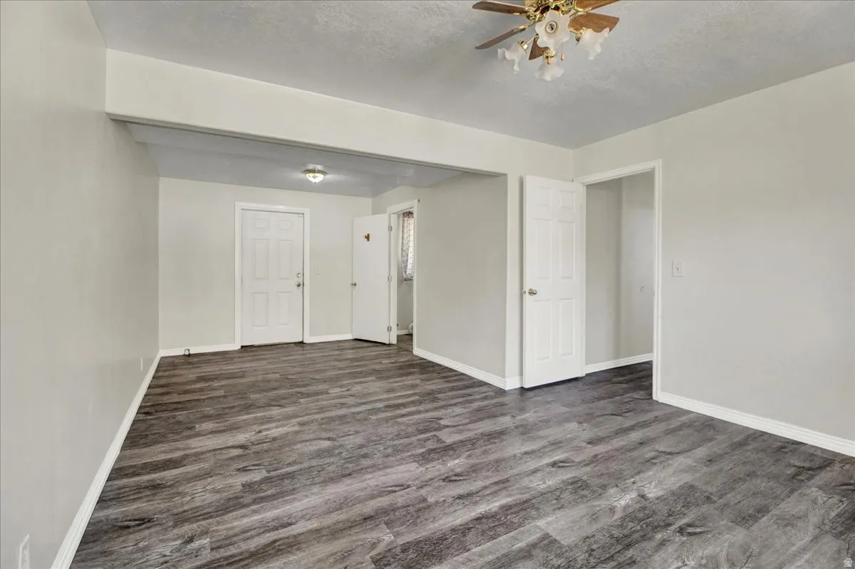 Spacious interior featuring wood-finish flooring, light grey wall paint, and white trim
