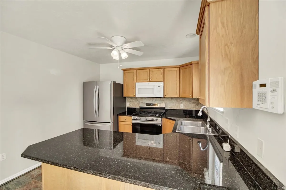 Kitchen featuring granite countertops, wood cabinetry, and stainless steel appliances