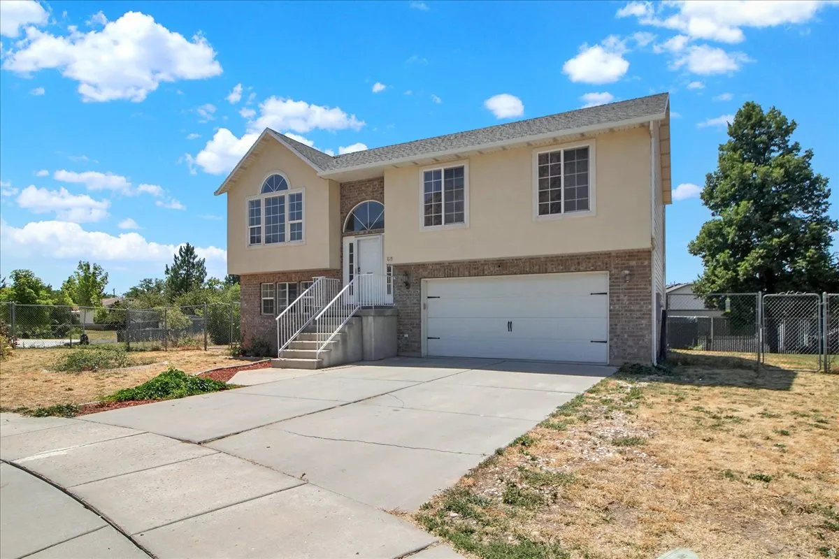 Two-story residence featuring a two-car garage, front entrance with arched transom window, and a concrete driveway