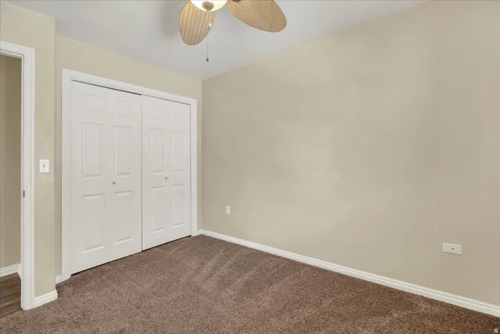 Room featuring neutral-toned walls, brown carpeting, and white baseboards