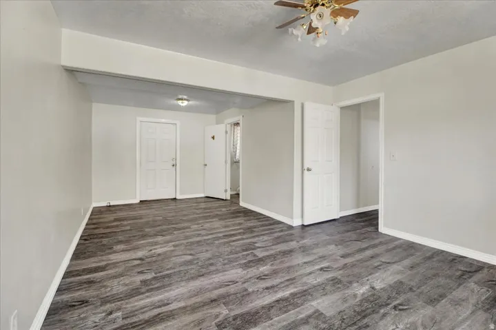 Spacious interior featuring wood-finish flooring, light grey wall paint, and white trim