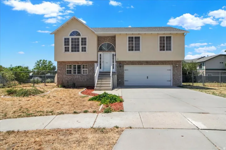 Two-story property featuring a stucco and brick facade, an attached two-car garage, and a concrete driveway