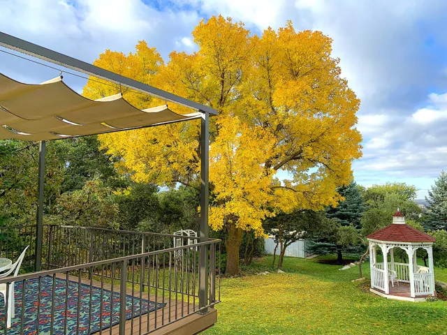 Expansive outdoor deck with a retractable canopy, durable railing, and wood-finish flooring