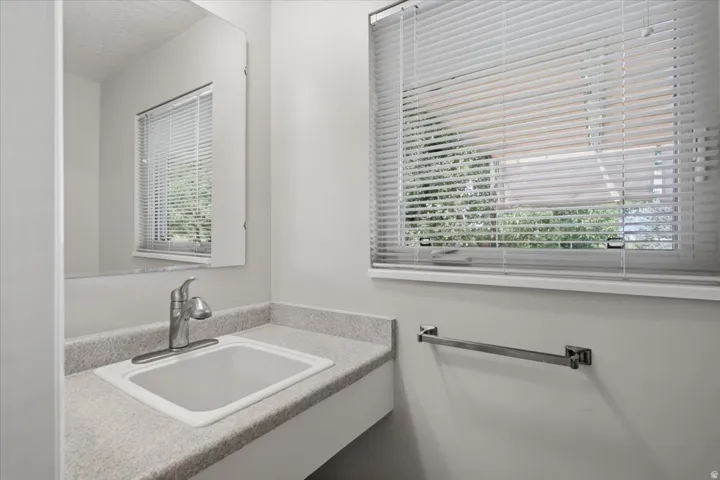 Bathroom vanity with an integrated sink, granite-look countertop, and a single-handle chrome faucet