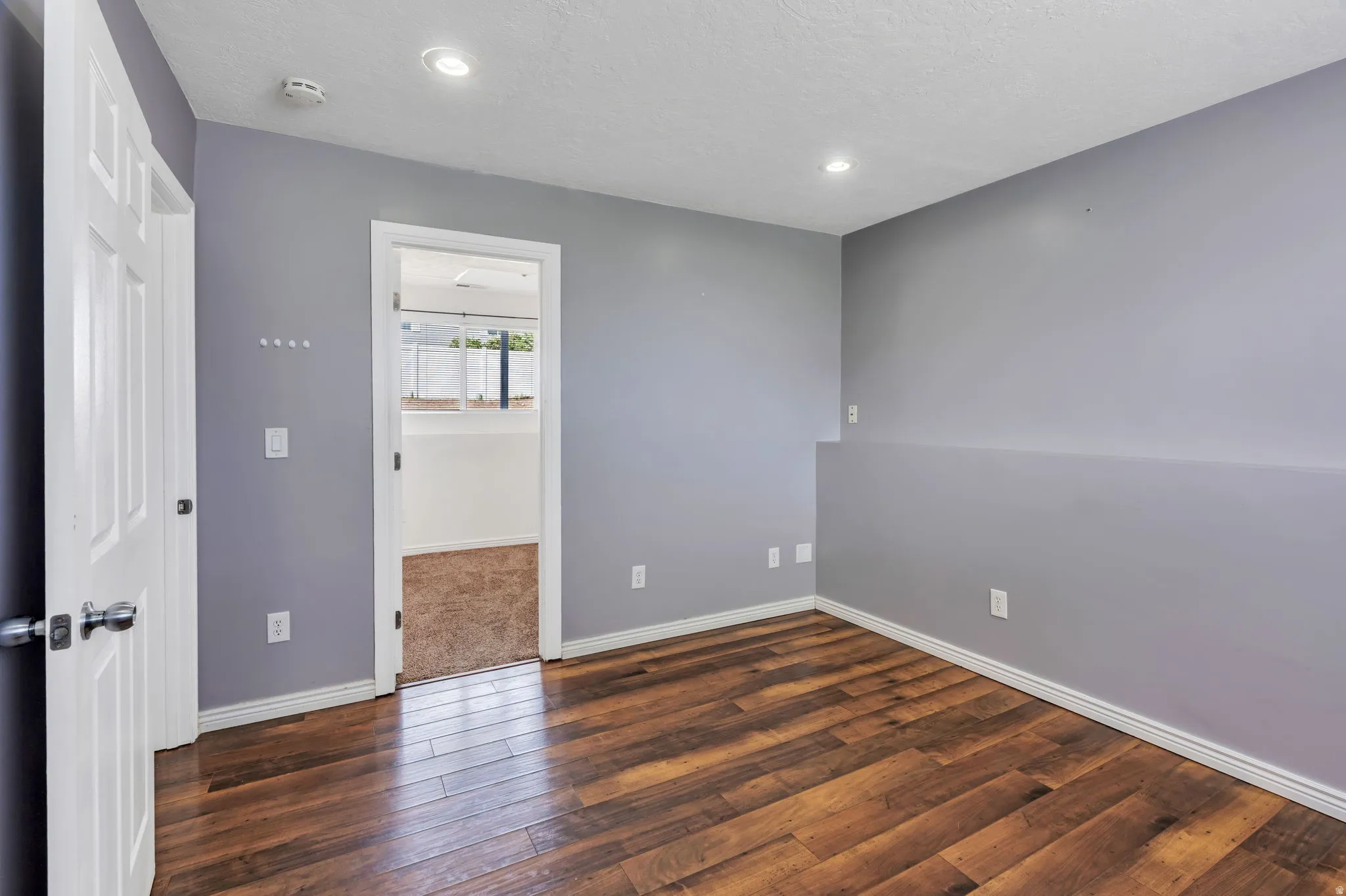 Interior room featuring wood-finish flooring, light gray walls, white trim, and recessed lighting