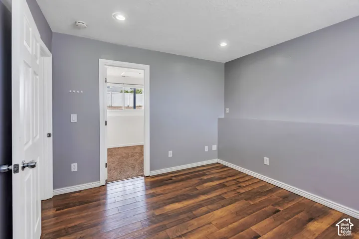 Interior room featuring wood-finish flooring, light gray walls, white trim, and recessed lighting