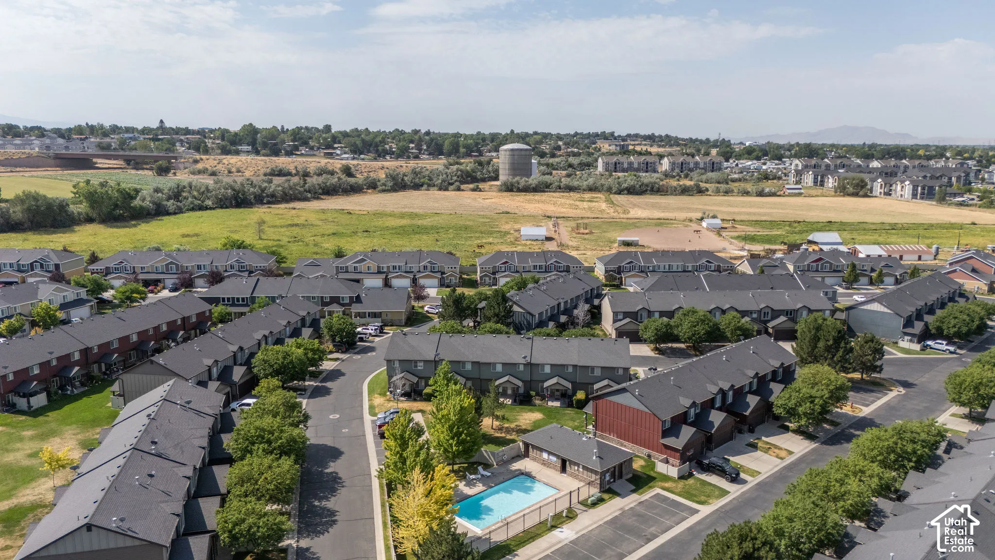 Residential community featuring townhomes with dark shingled roofs and light-colored siding
