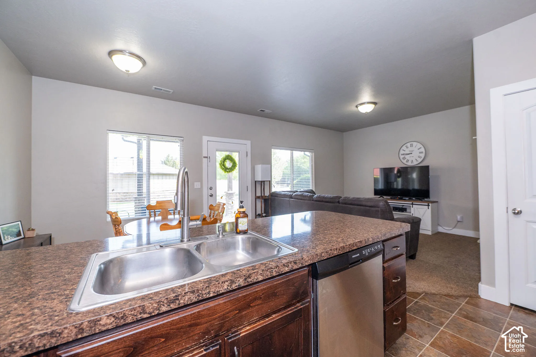 Kitchen island with a double basin stainless steel sink, pull-down faucet, and integrated dishwasher