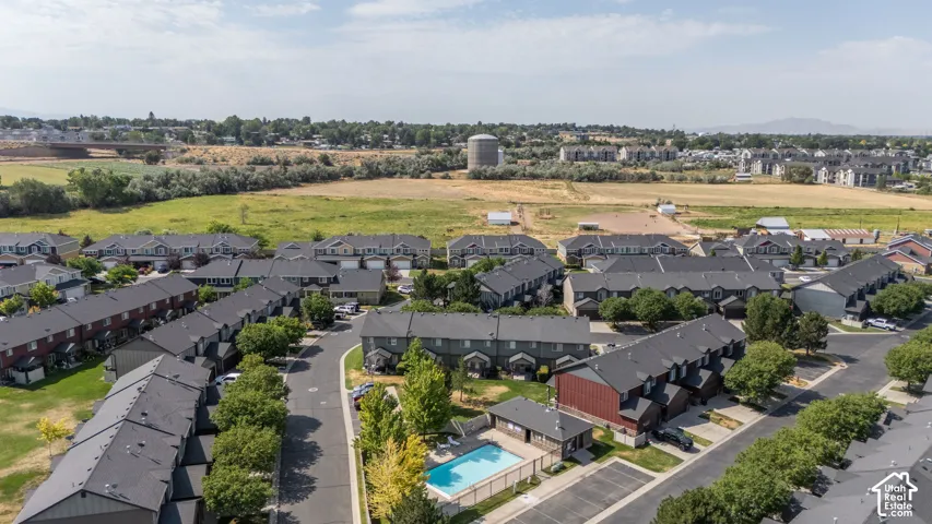 Residential community featuring townhomes with dark shingled roofs and light-colored siding