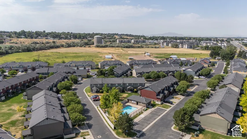 Aerial perspective of a multi-unit residential development featuring a central swimming pool and surrounding green spaces