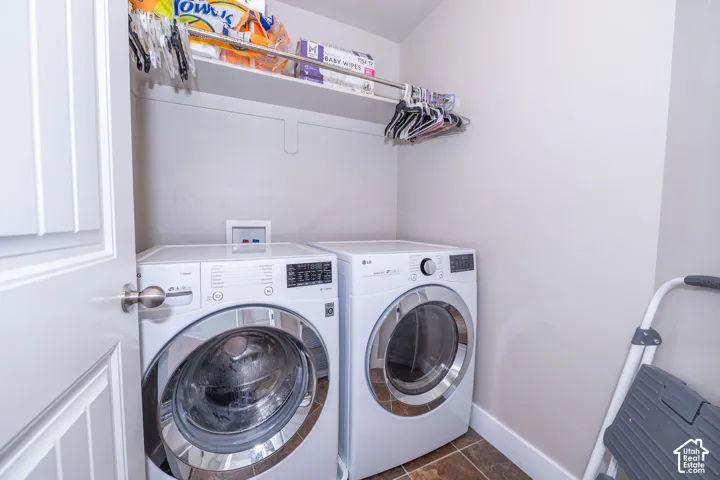Dedicated laundry area featuring front-loading appliances, a built-in shelf, and a hanging rod
