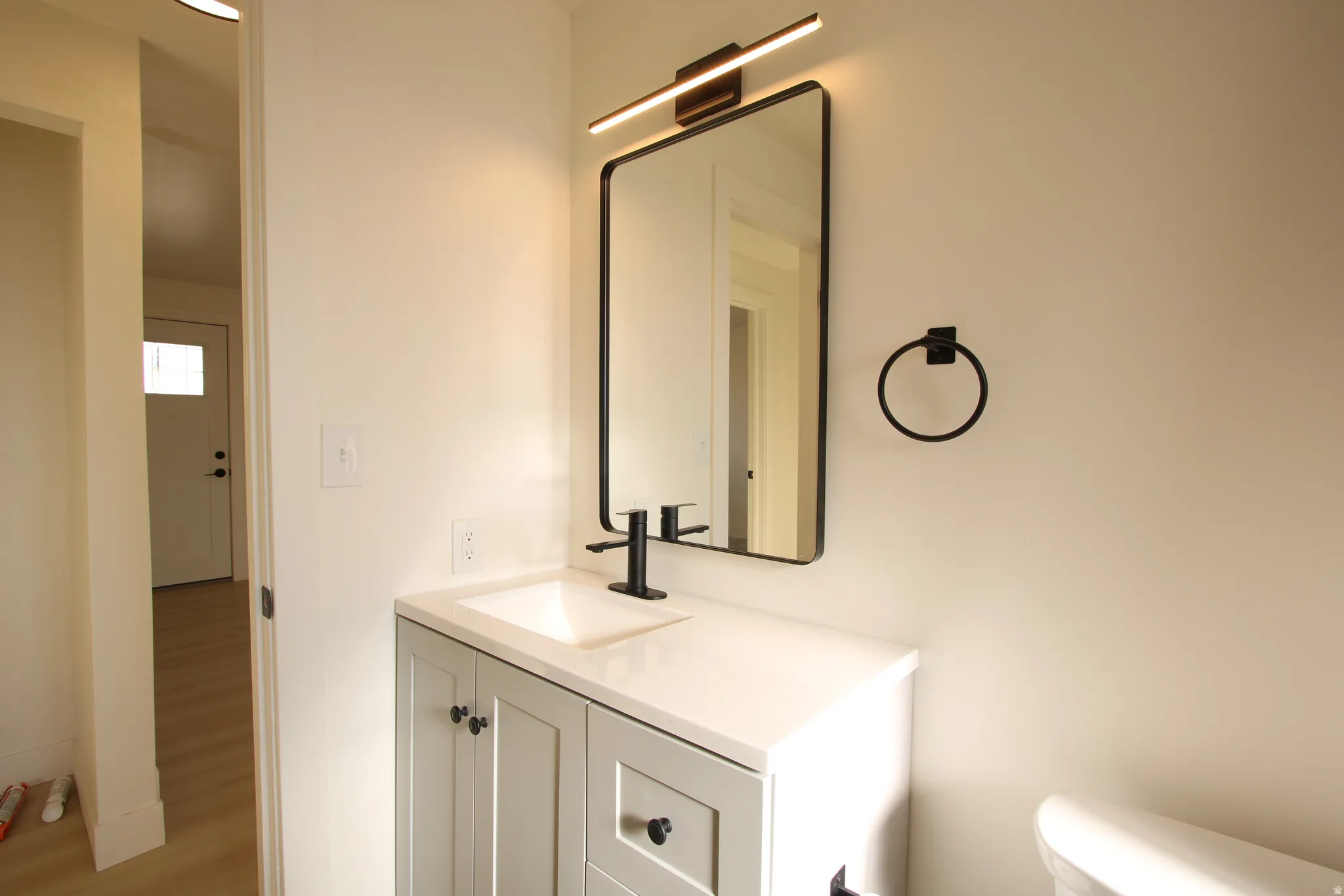 Bathroom vanity featuring a white countertop, undermount sink, and matte black faucet