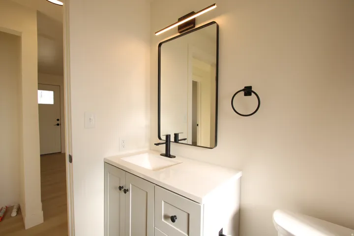 Bathroom vanity featuring a white countertop, undermount sink, and matte black faucet