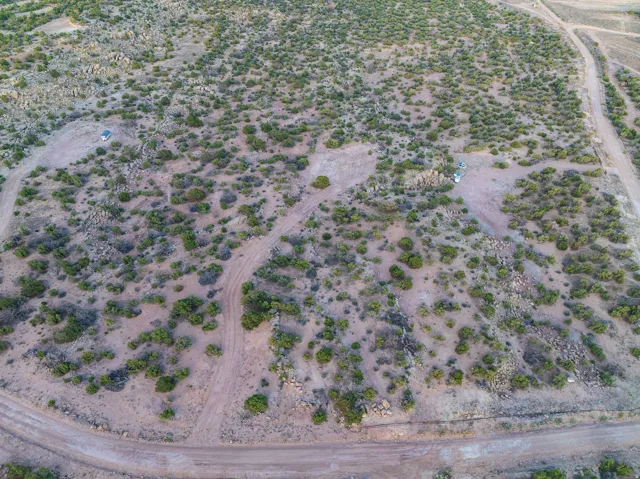 Expansive open land with natural desert vegetation and visible dirt paths