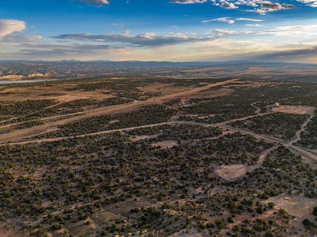 Expansive desert landscape featuring natural scrub brush and several unpaved roads