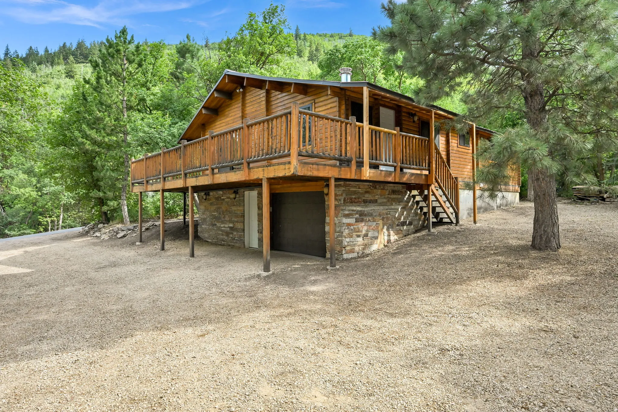 Wood-sided cabin-style residence featuring a prominent elevated wood deck with railings