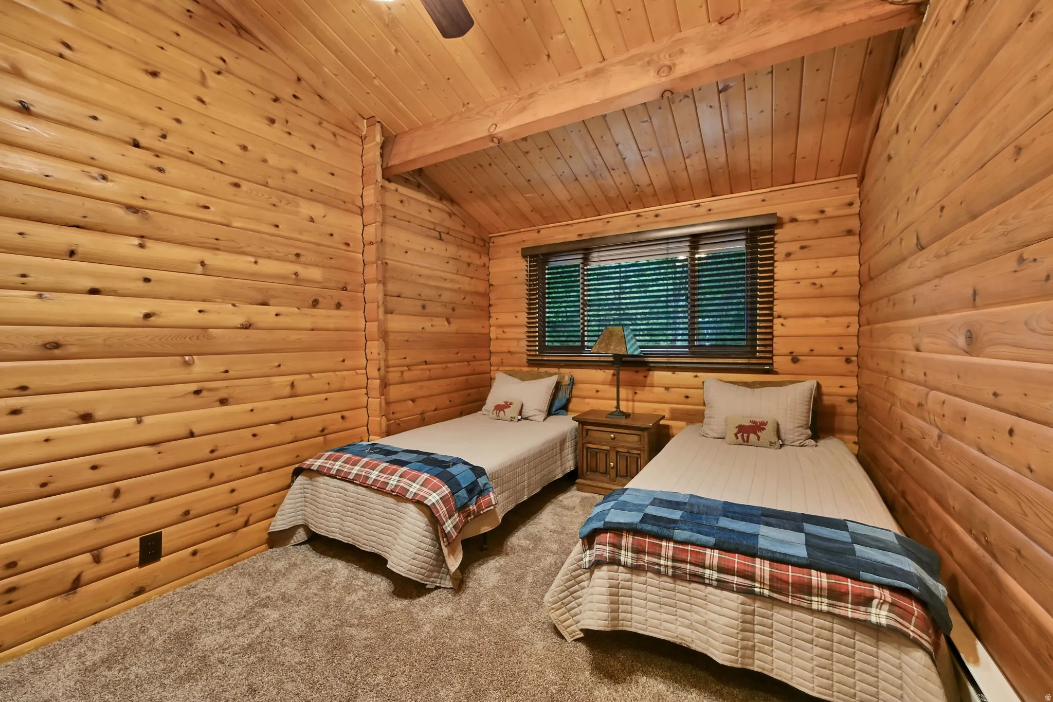 Room featuring extensive wood paneling, a vaulted wood-plank ceiling with exposed beams, and a window with blinds